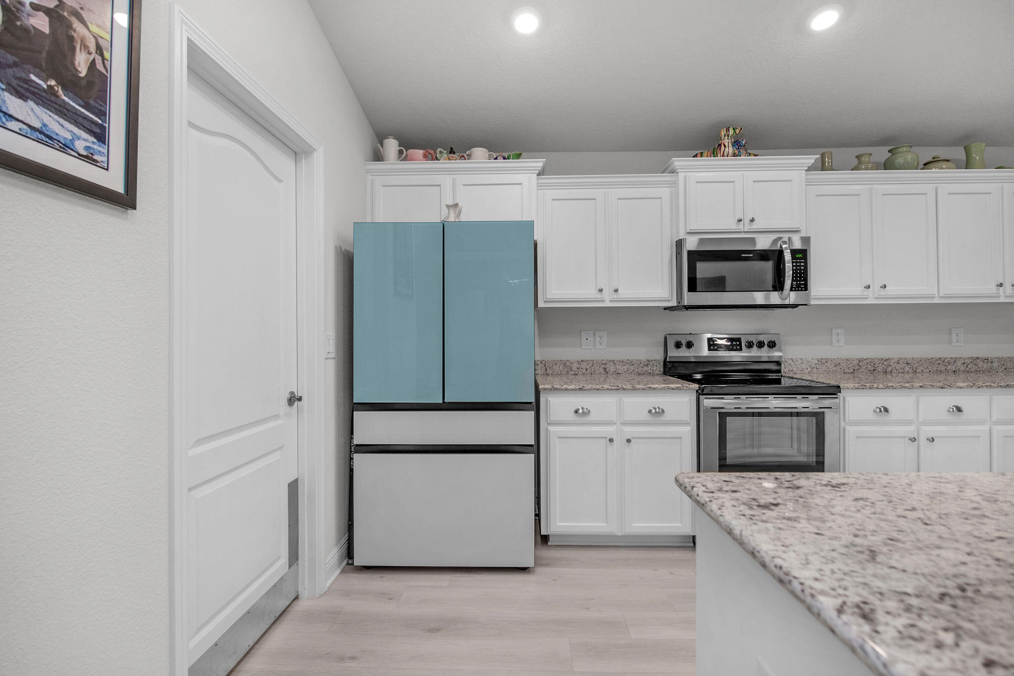 2099 Queen Street Crestview, FL 32536 - Photo 11 of 36 a kitchen with granite countertop a refrigerator stove and white cabinets
