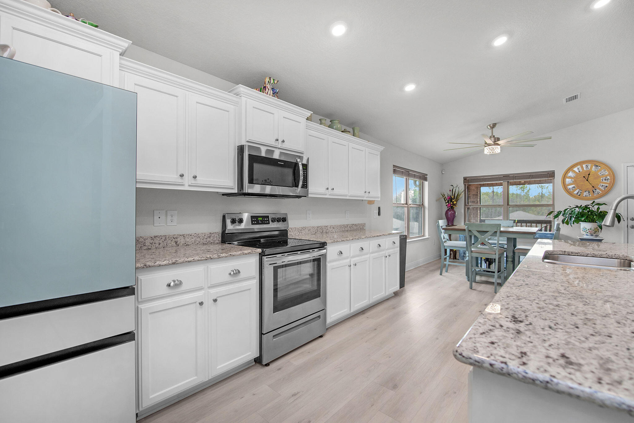 2099 Queen Street Crestview, FL 32536 - Photo 12 of 36 a open kitchen with stainless steel appliances granite countertop a stove top oven a sink dishwasher and white cabinets with wooden floor