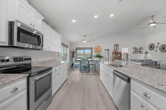 a kitchen with stainless steel appliances granite countertop a stove and cabinets