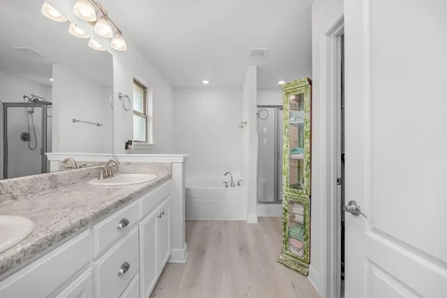 a bathroom with a granite countertop sink a large mirror and a shower