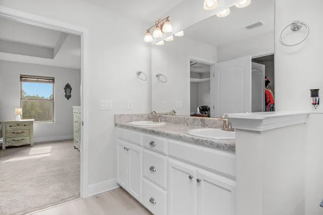 a bathroom with a granite countertop sink a large mirror and a shower