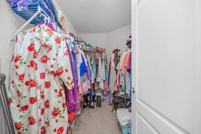 a view of walk in closet with clothes