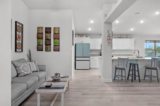 a living room with furniture and kitchen view
