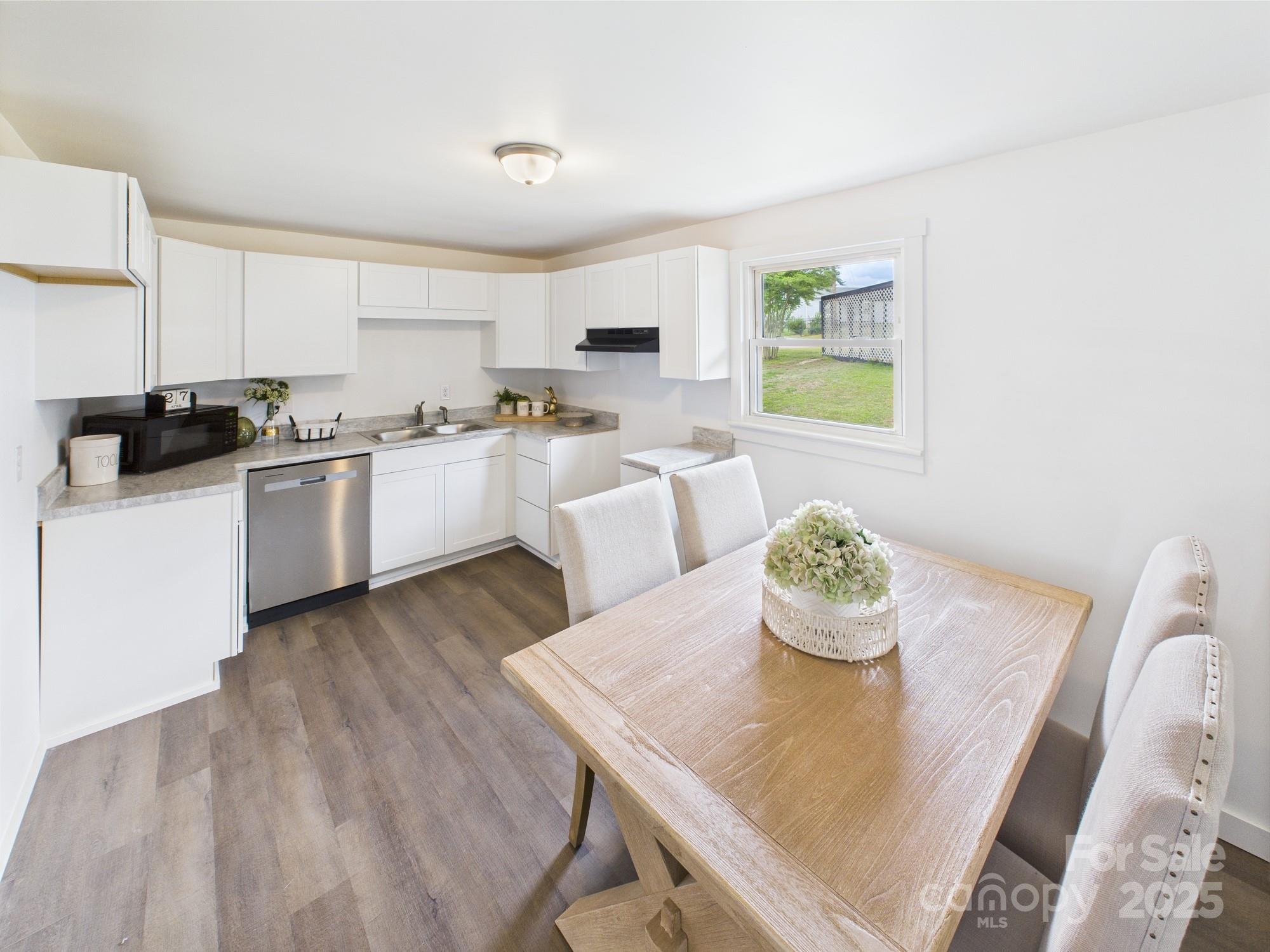 120 Hepler Road Taylorsville, NC 28681 - Photo 8 of 20 a kitchen with stainless steel appliances a stove a sink a microwave a dining table and chairs