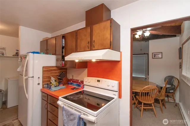 a kitchen with a refrigerator and a stove top oven