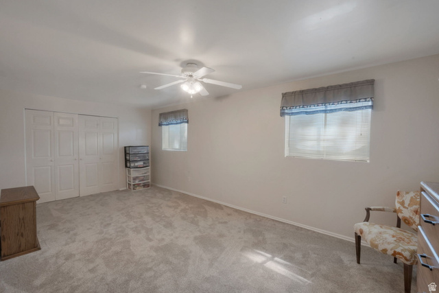 11072 Windy Peak Ridge Drive, Unit 32 Sandy, UT 84094 - Photo 27 of 30 Carpeted interior space featuring dual windows with blinds, a ceiling fan, and bi-fold closet doors