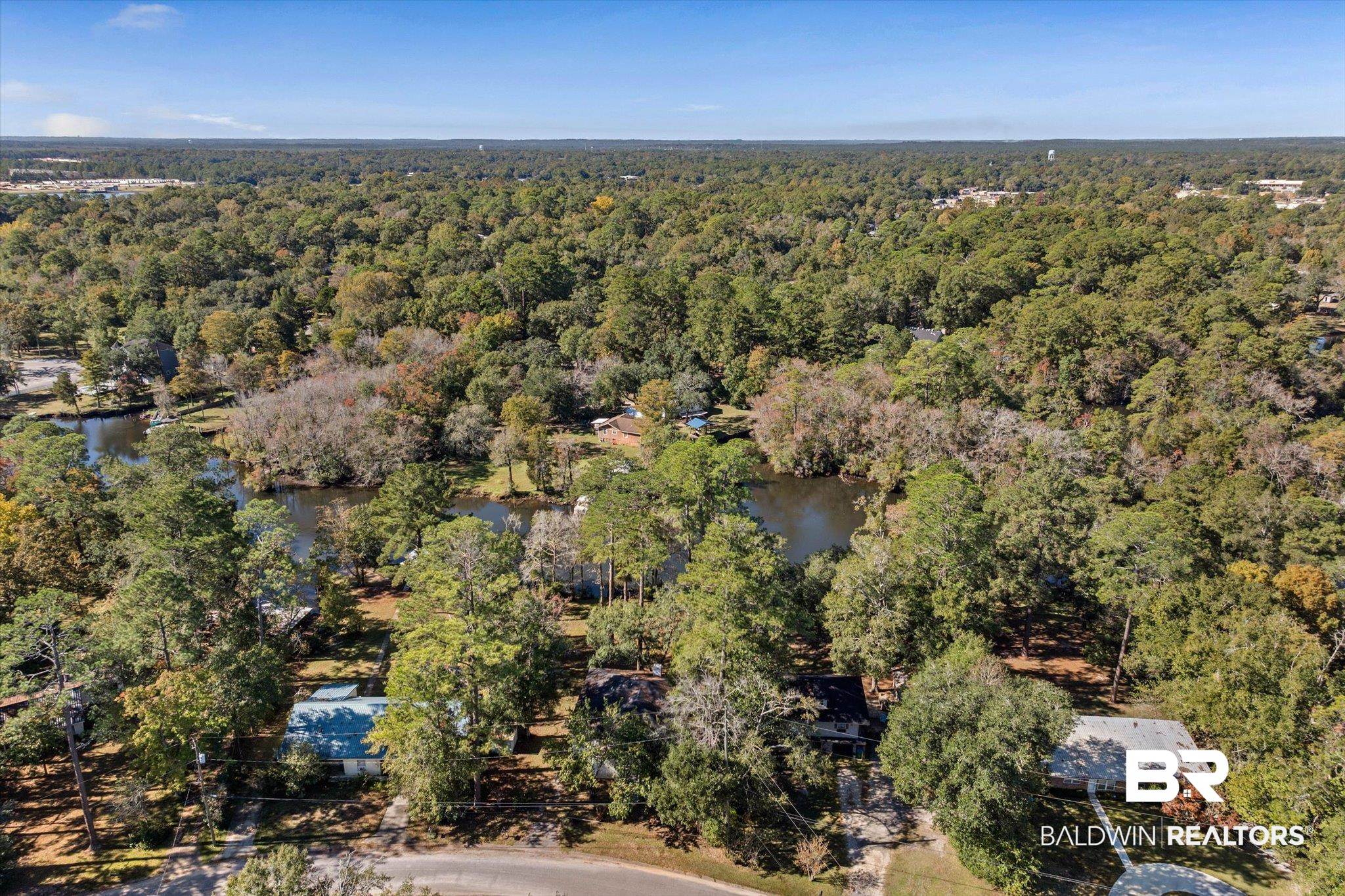 431 Simms Drive Saraland, AL 36571 - Photo 31 of 34 Aerial view of property and surrounding area featuring a large body of water and a heavily wooded area
