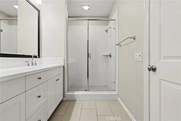a bathroom with a double vanity sink mirror and shower