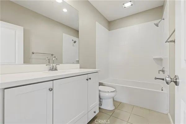 a bathroom with a granite countertop sink a toilet and shower