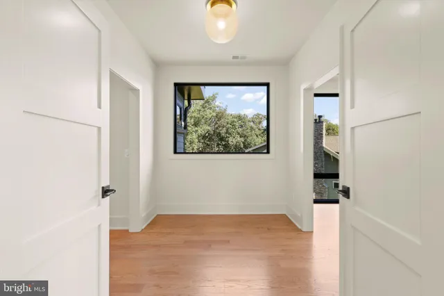 an empty room with wooden floor and windows
