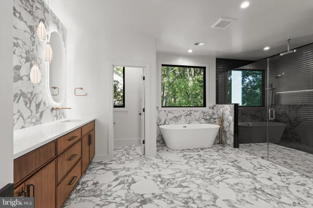 a view of an empty room with wooden floor and a kitchen