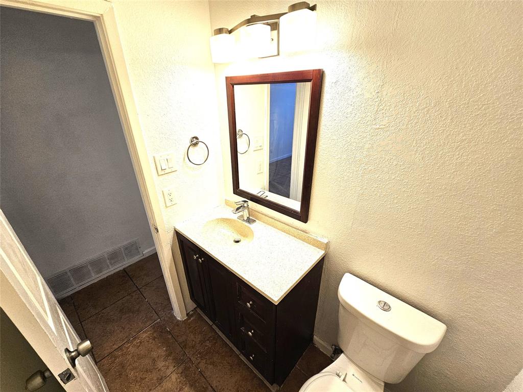 724 Bluebonnet Drive, Unit A Keller, TX 76248 - Photo 16 of 27 a bathroom with a toilet sink vanity and mirror