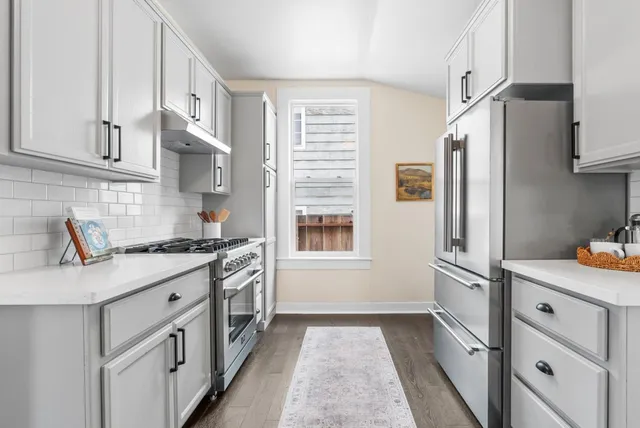 a kitchen with stainless steel appliances granite countertop a sink stove and refrigerator