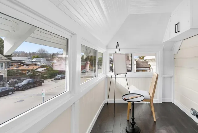 a view of a workspace with furniture and a window