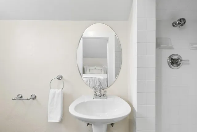 a bathroom with a sink a mirror and a shower