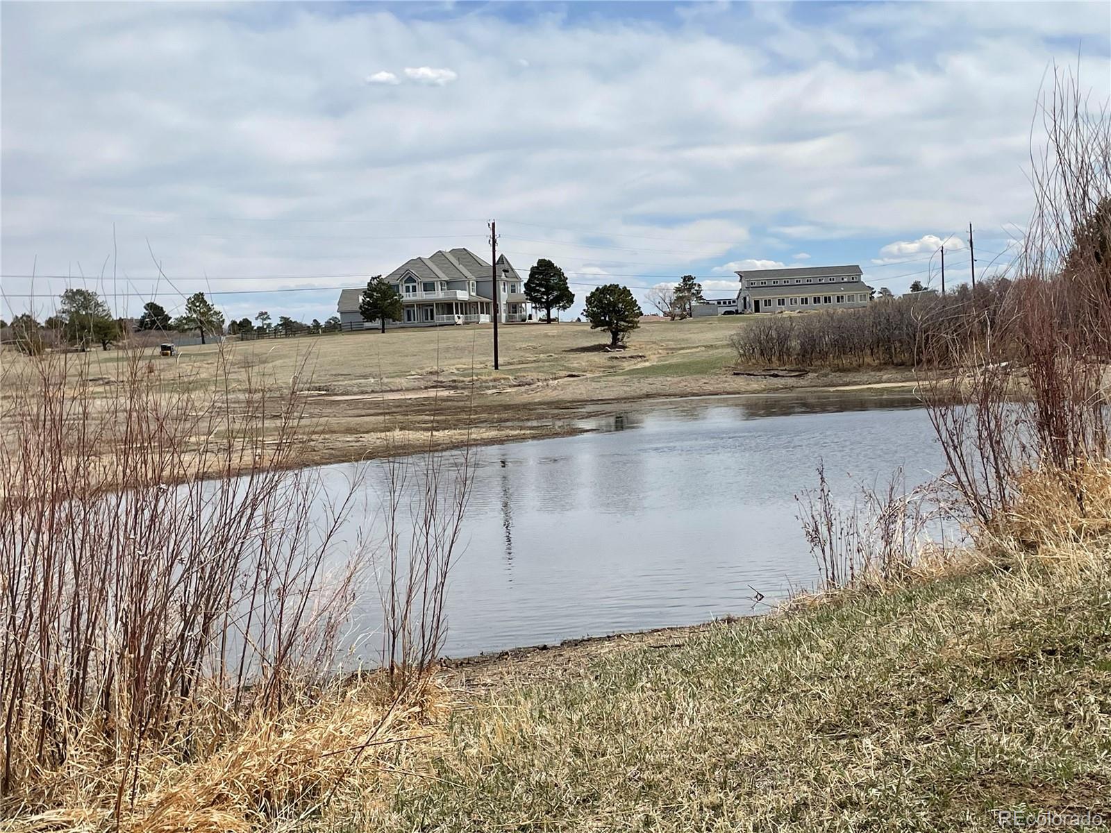 727 East Rim Road Franktown, CO 80116 - Photo 12 of 40 a view of a lake with a big yard