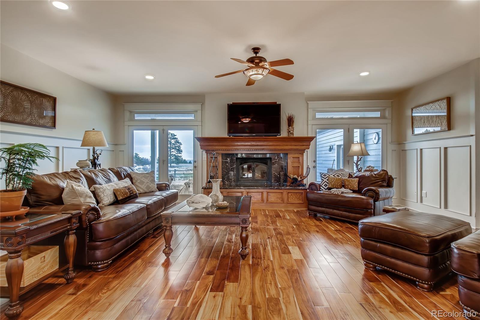 727 East Rim Road Franktown, CO 80116 - Photo 14 of 40 a living room with furniture a flat screen tv and a fireplace
