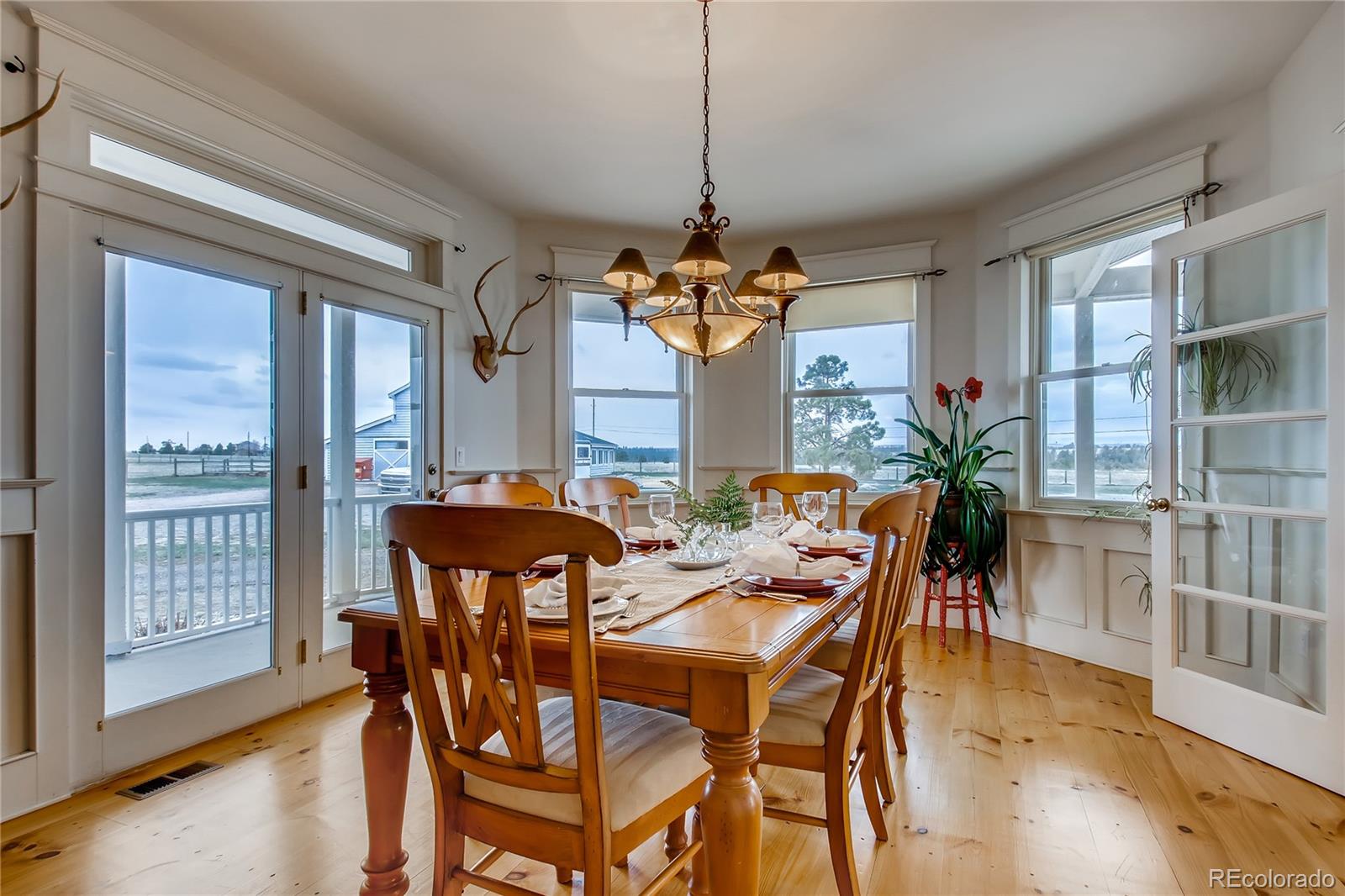 727 East Rim Road Franktown, CO 80116 - Photo 17 of 40 a dining room with furniture a chandelier and wooden floor
