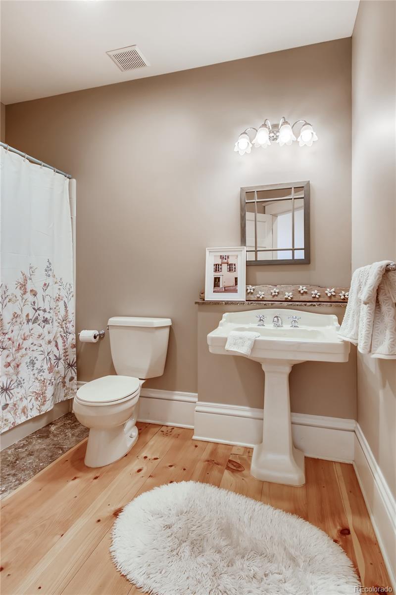 727 East Rim Road Franktown, CO 80116 - Photo 23 of 40 a spacious bathroom with a toilet a sink and a mirror