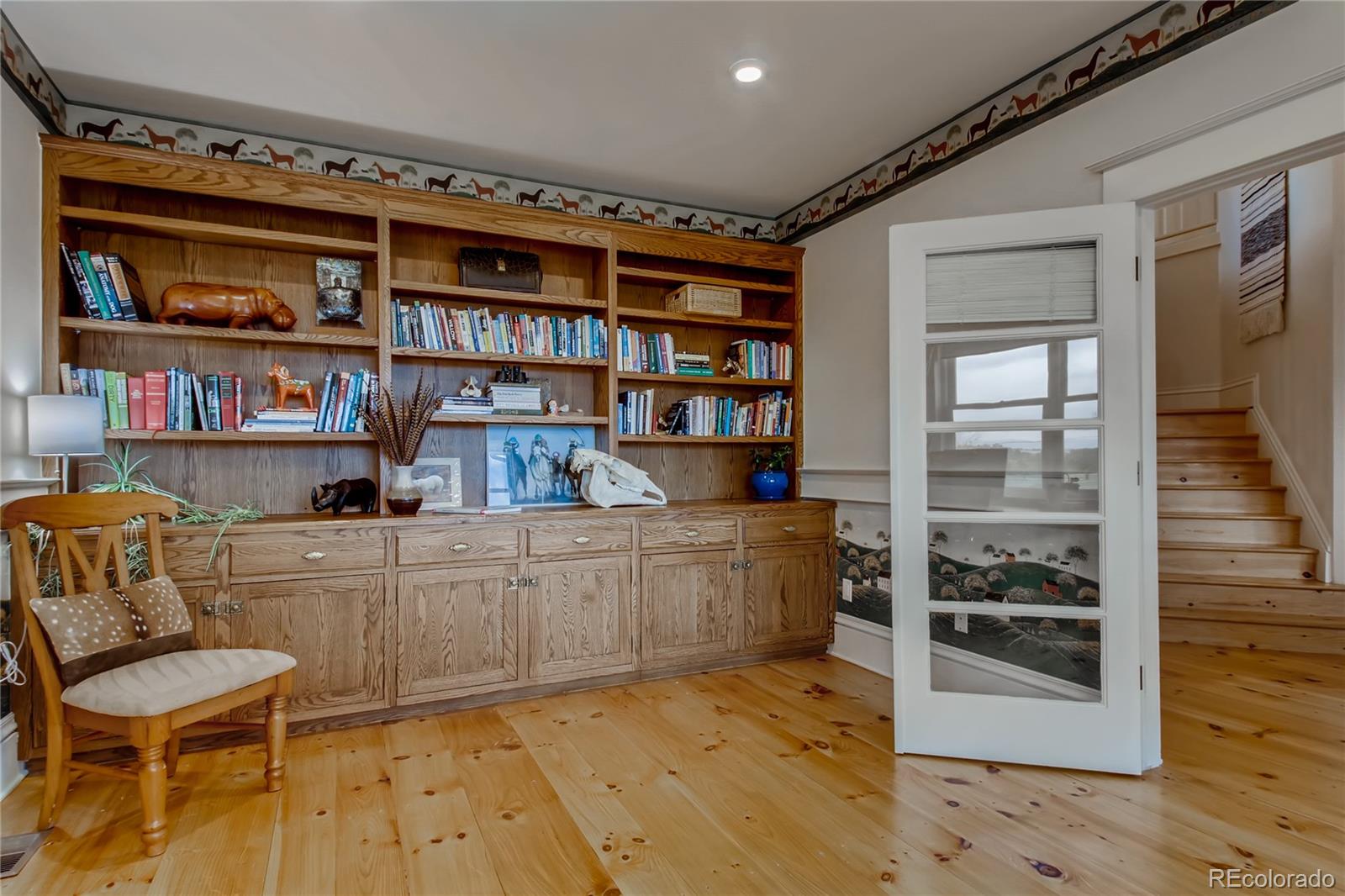 727 East Rim Road Franktown, CO 80116 - Photo 28 of 40 a room with a bookshelf and a wooden floor