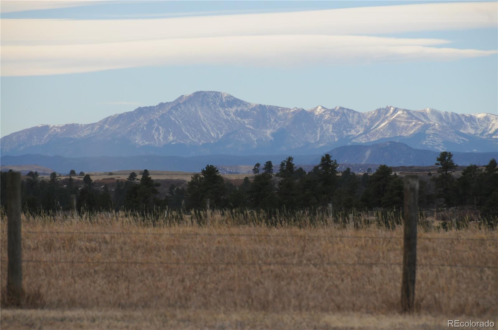 727 East Rim Road Franktown, CO 80116 - Photo 5 of 40 a view of a lush green hillside and a mountain