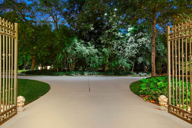 a view of a white house with a big yard and large trees