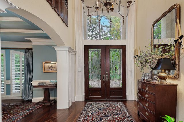 a spacious bedroom with a bed a dresser and a chandelier