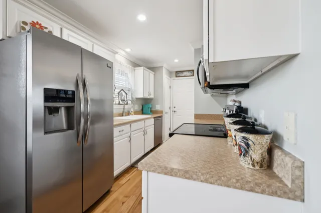 a kitchen with stainless steel appliances granite countertop a sink a stove and a refrigerator