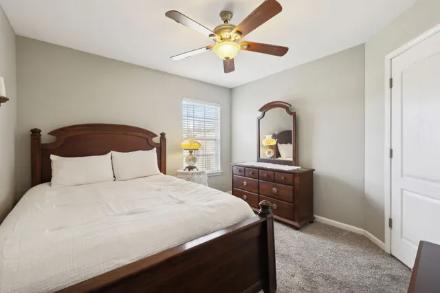 a bedroom with a bed and a dresser with mirror