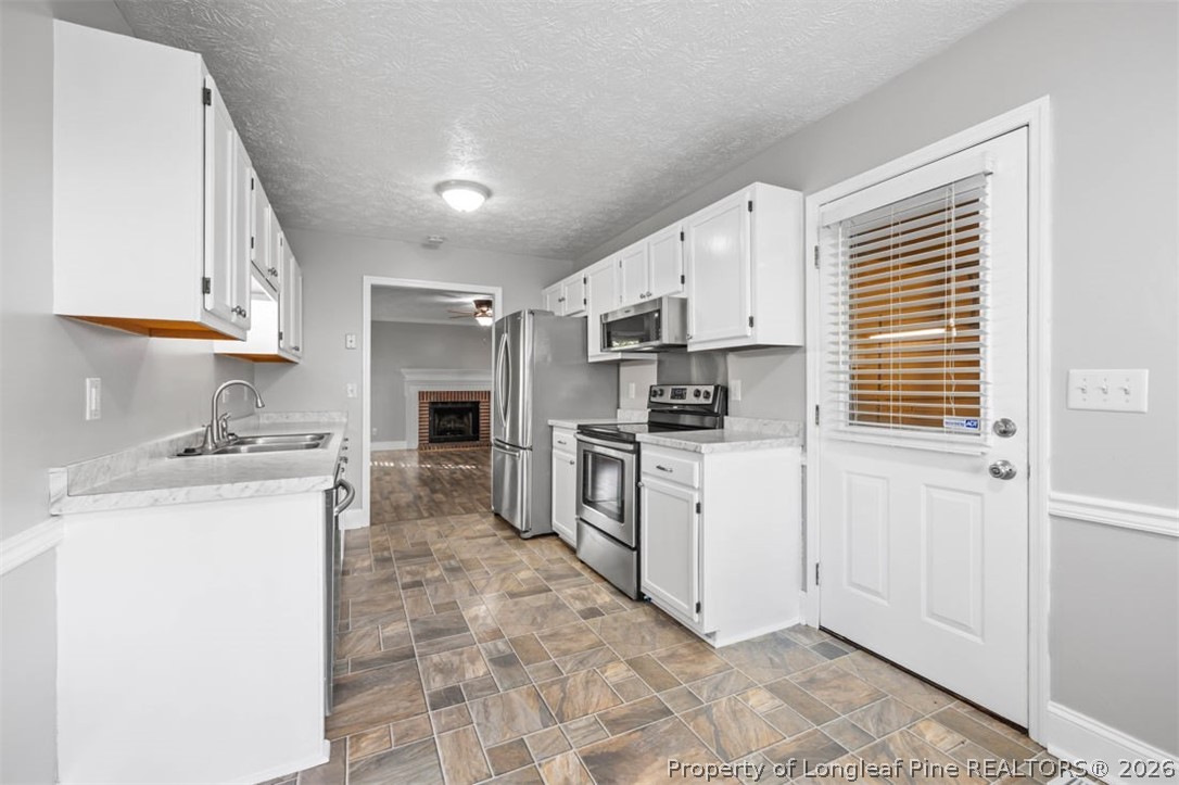 1205 Crossbend Court Fayetteville, NC 28314 - Photo 15 of 37 a kitchen with white cabinets and white appliances