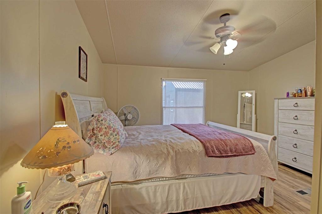 2004 Fall Creek Road Cleburne, TX 76033 - Photo 13 of 18 a bedroom with a bed and chandelier