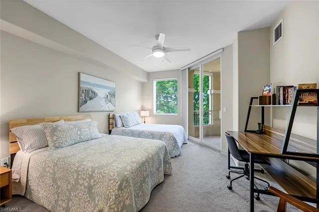 a bedroom with a large bed a large window and a chandelier