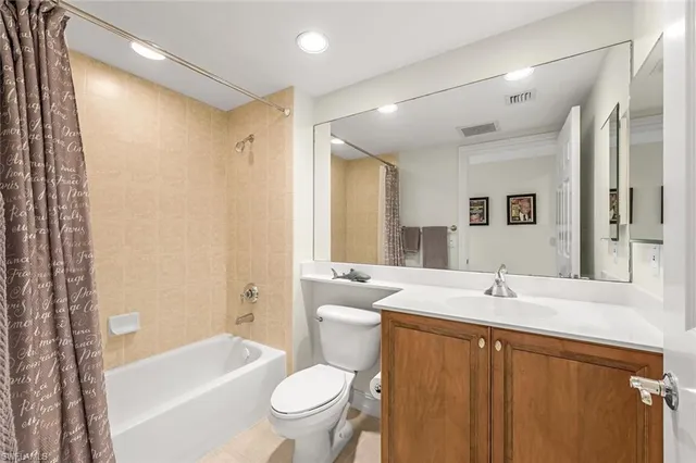 a bathroom with a double vanity sink toilet mirror and bathtub