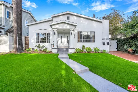 a front view of a house with garden and plants