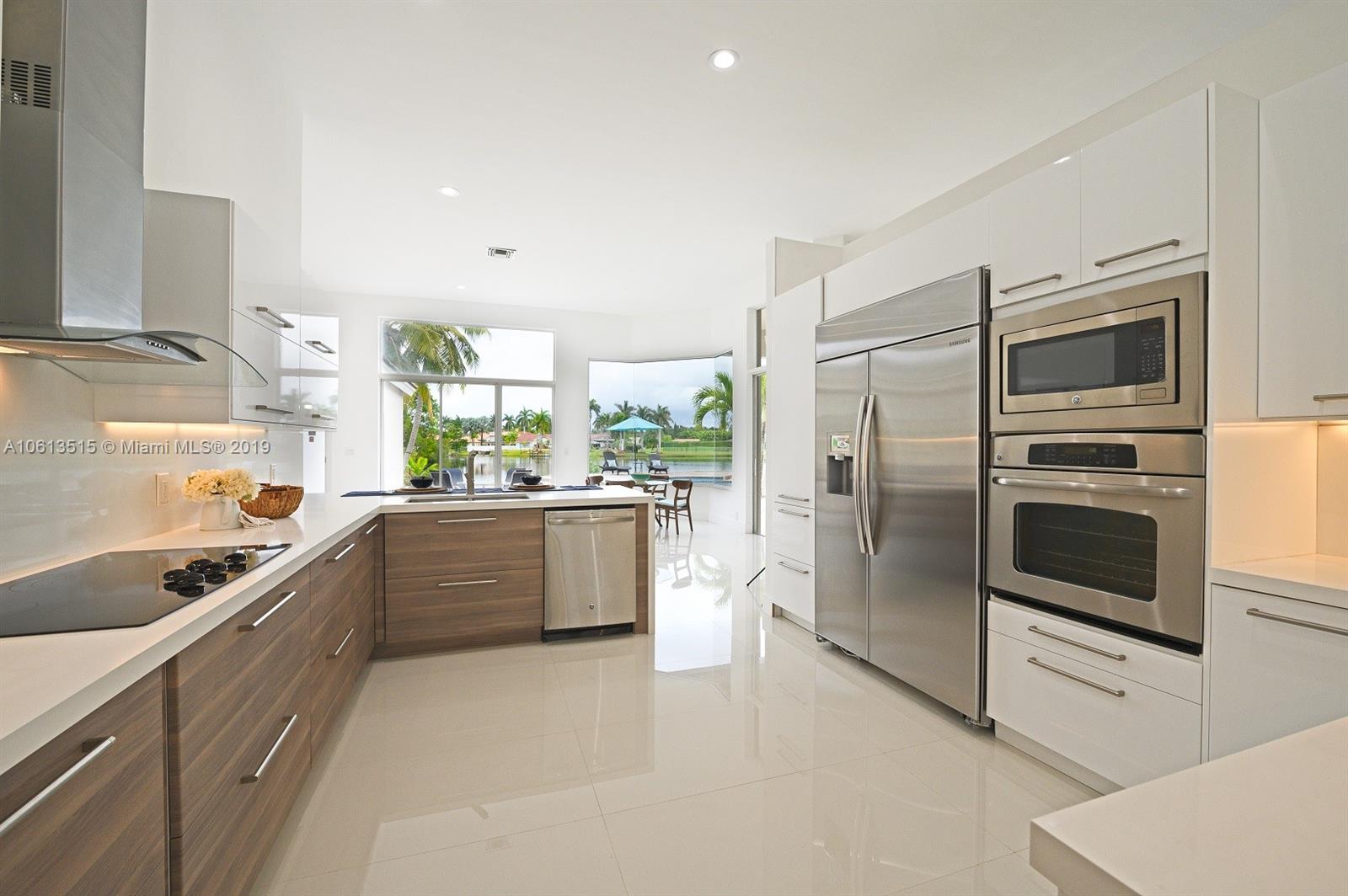 561 Ranch Road Weston, FL 33326 - Photo 10 of 46 a kitchen with stainless steel appliances kitchen island granite countertop a refrigerator and a stove top oven
