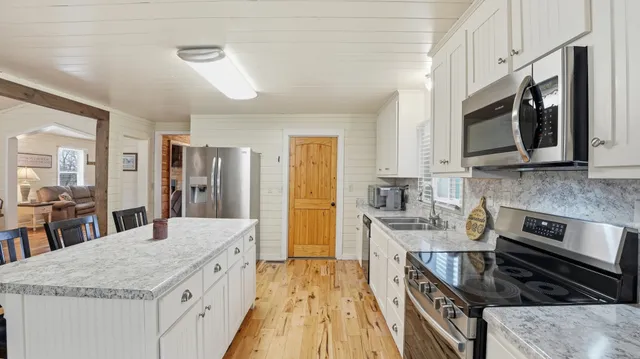 a kitchen with granite countertop a sink stove and microwave