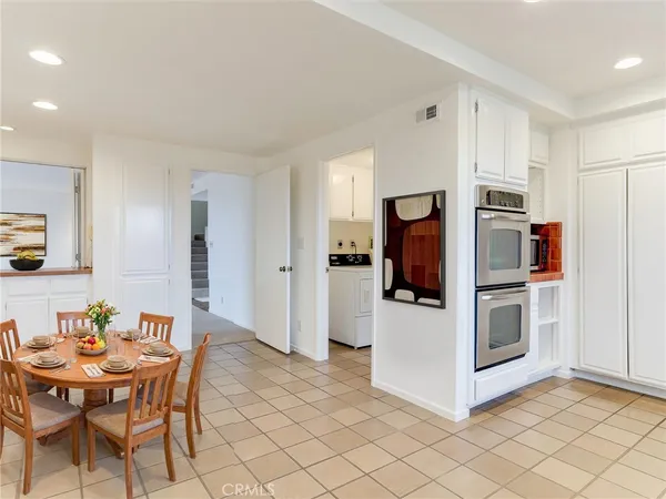 a kitchen with granite countertop white cabinets stainless steel appliances and a counter space
