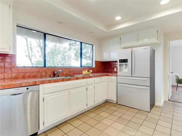 a view of a kitchen with a sink and an open kitchen view
