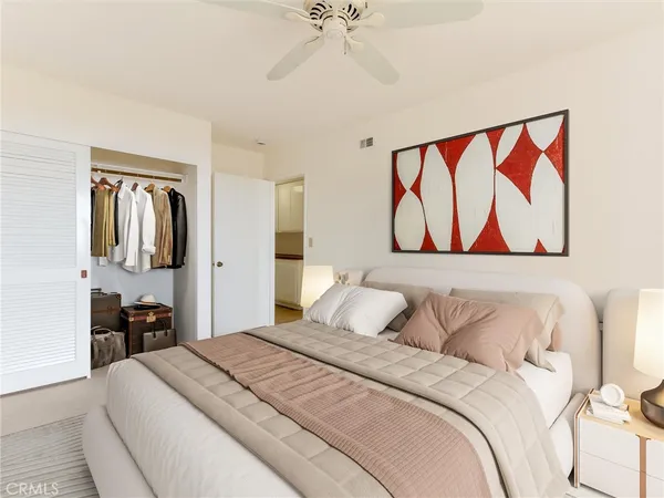 a bedroom with bed painting on wall and two large window