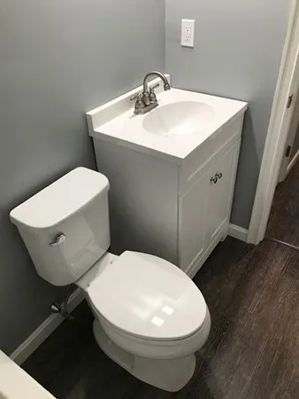 a bathroom with a toilet sink and mirror