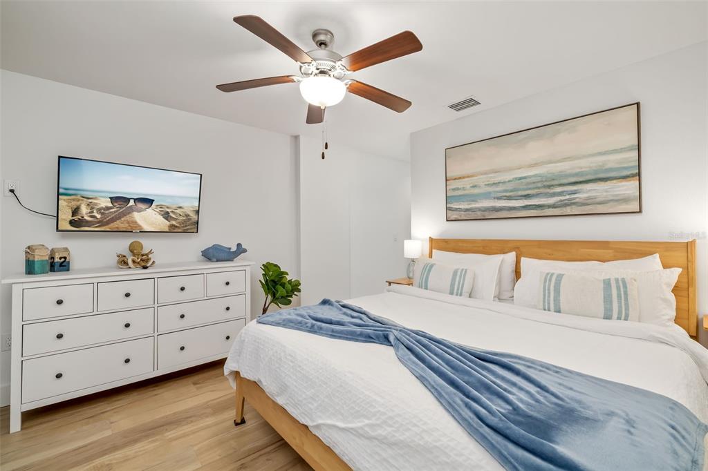 15305 1st Street East, Unit 201 Madeira Beach, FL 33708 - Photo 24 of 41 a bedroom with a bed and a dresser