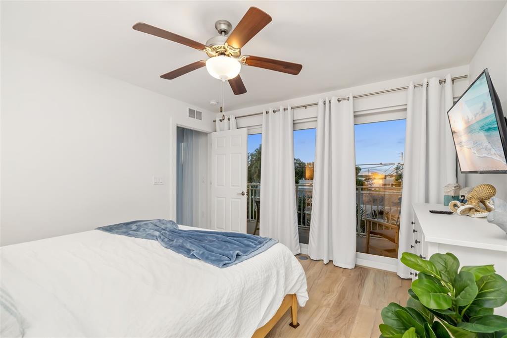 15305 1st Street East, Unit 201 Madeira Beach, FL 33708 - Photo 25 of 41 a bedroom with a bed and a chandelier