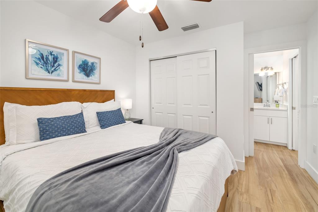 15305 1st Street East, Unit 201 Madeira Beach, FL 33708 - Photo 26 of 41 a bedroom with a large bed and a chandelier