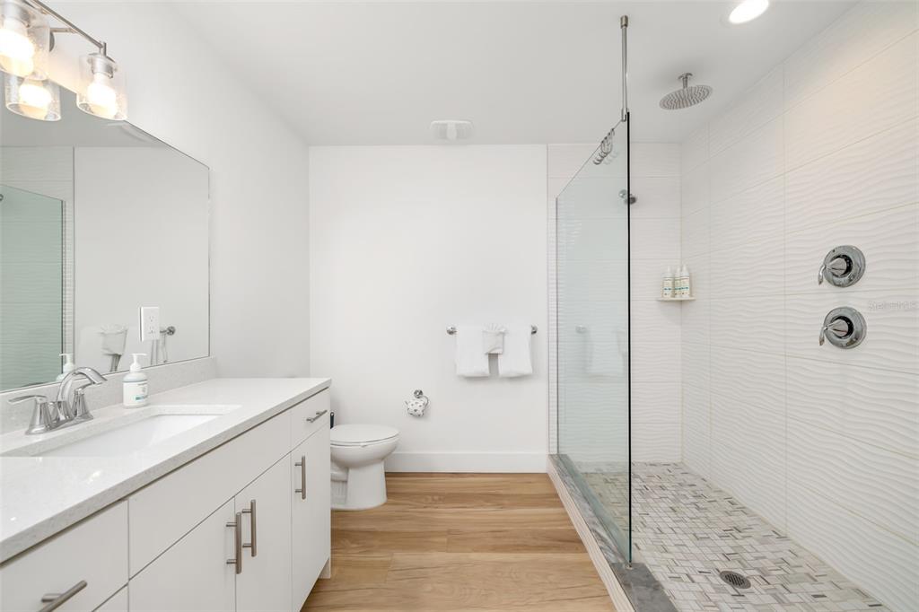 15305 1st Street East, Unit 201 Madeira Beach, FL 33708 - Photo 27 of 41 a bathroom with a sink a toilet and shower