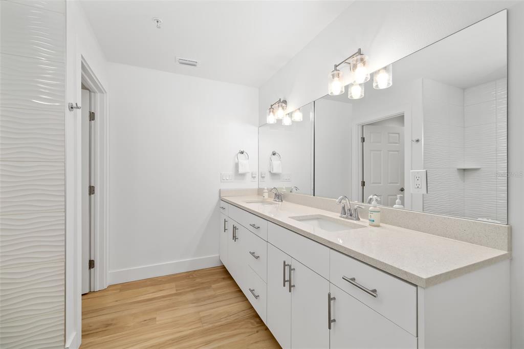 15305 1st Street East, Unit 201 Madeira Beach, FL 33708 - Photo 31 of 41 a bathroom with a double vanity sink and a mirror