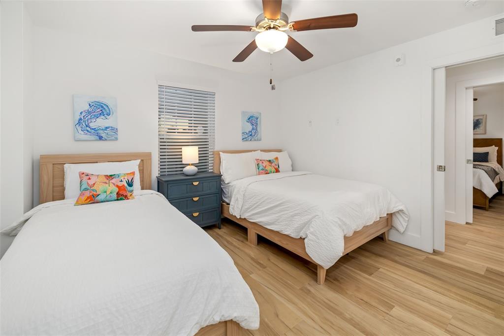 15305 1st Street East, Unit 201 Madeira Beach, FL 33708 - Photo 32 of 41 a bedroom with a bed and wooden floor