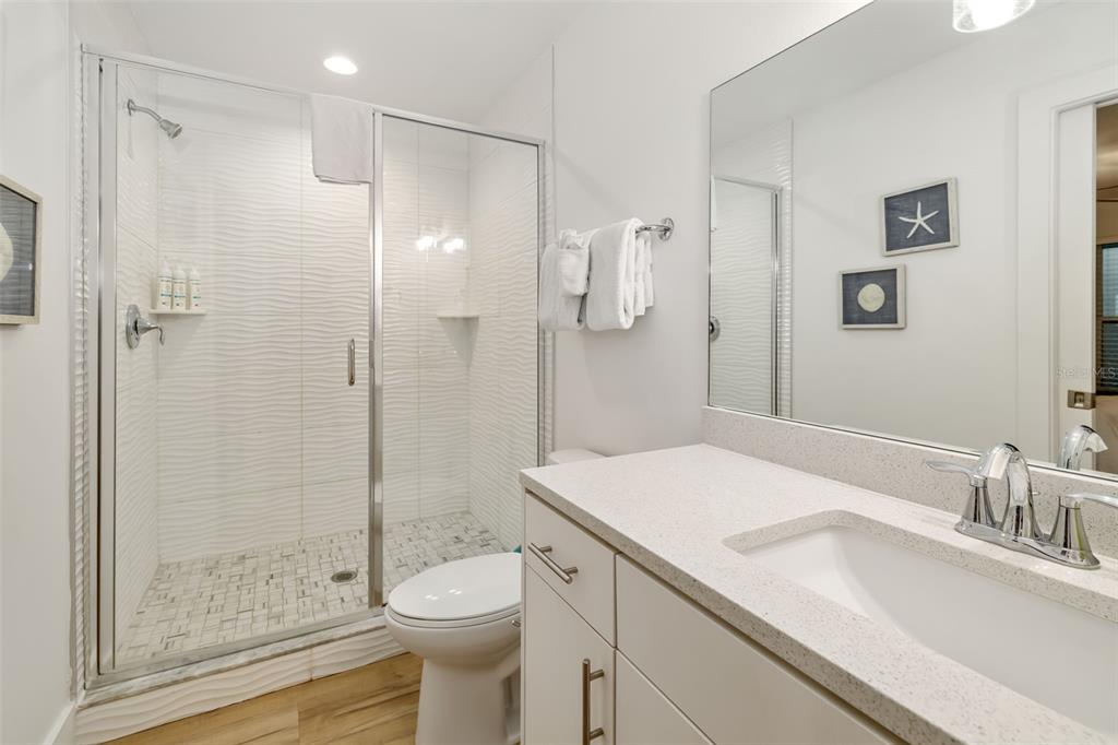 15305 1st Street East, Unit 201 Madeira Beach, FL 33708 - Photo 33 of 41 a bathroom with a sink a toilet and shower