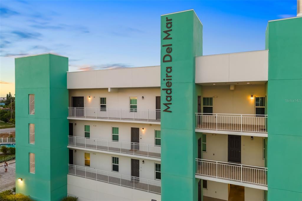 15305 1st Street East, Unit 201 Madeira Beach, FL 33708 - Photo 9 of 41 a front view of a house with a green yard