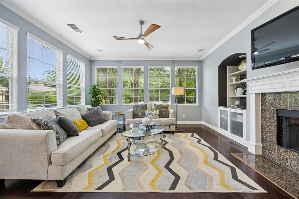 5808 Rathbone Drive Parker, TX 75002 - Photo 14 of 39 The family room with so many windows has fantastic views and natural light! The space has hardwood flooring, fireplace with granite tile work that matches the kitchen, and convenient built-in unit.