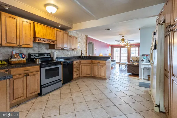 a kitchen with stainless steel appliances granite countertop a stove top oven a sink a counter top space cabinets and a window